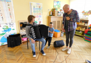 Radek z grupy Słoneczek uruchamia akordeon pana Olka rozciągając miech.