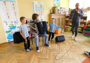 Chłopcy z grupy Słoneczek próbują grać na akordeonie.