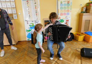 Karolina z grupy Biedronek naciska na akordeonie guziki zmieniające barwę dźwięku.