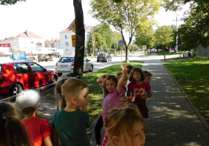 Dzieci przyglądają się znakom przy przedszkolu.