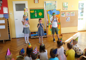 Reprezentanci grupy „Słoneczka”, „Biedronki” i „Żabki” dmuchają balony.