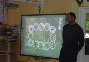 Leśnik przedstawia na tablicy interaktywnej życie zwierząt i roślin w lesie