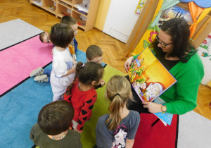 Mama Karinki, pani Karolina Szymczak pokazuje dzieciom ilustracje w książce.