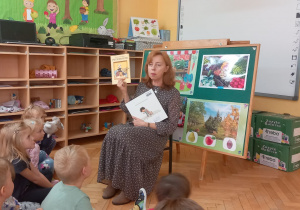 Pani Ilona pokazuje dzieciom wybrane do czytania książki.