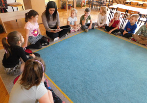 Dzieci z grupy "Biedronek" uważnie słuchają opowiadania, które czyta pani Anetka.