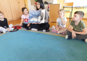 Pani Anetka pokazuje dzieciom ilustracje w książce.