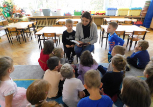 Dzieci z grupy Biedronek uważnie słuchają bajki czytanej przez panią Aleksandrę Grzelak.