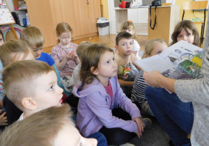 Dzieci w skupieniu słuchają bajki czytanej przez panią Aleksandrę Grzelak.