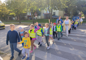 Dzieci z Paniami przechodzą przez przejście dla pieszych.