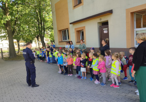 Dzieci stoją na placu przed Panem Policjantem.