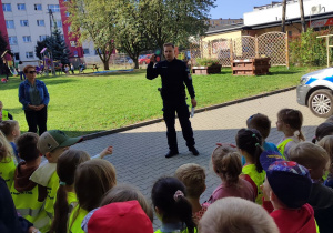 Pan Policjant pokazuje dzieciom sygnalizator świetlny.
