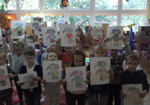 Przedszkolaki pokazują pomalowanego bohatera bajki.