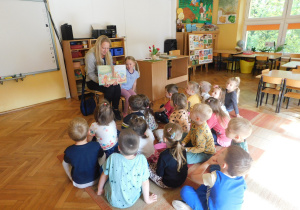 Dzieci oglądają ilustrację do bajki pt. „Kubuś Puchatek. Złoty skarb”.