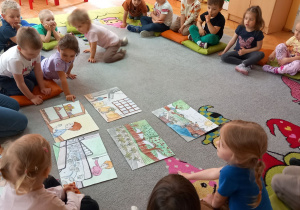 Dzieci układają historyjkę na dywanie „Od buraka do lizaka”.