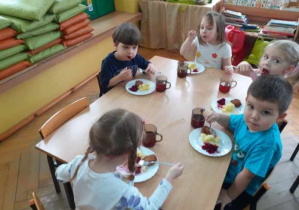 Dzieci ze smakiem zjadają buraczki.