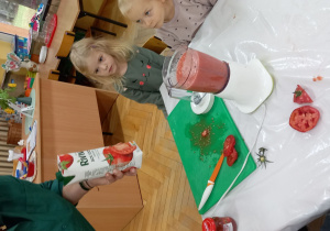 Pani Halinka tłumaczy dzieciom jakie produkty zawierają pomidory.