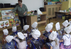 Pani Renia pokazuje dzieciom piramidę żywieniową.