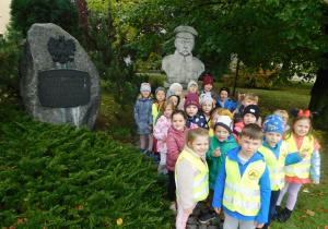 Dzieci z grupy Biedronek stoją pod pomnikiem Józefa Piłsudskiego.