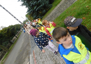 Mama Grzesiaowarzyszy dzieciom z grupy Biedronek podczas spaceru alejkami miasta.