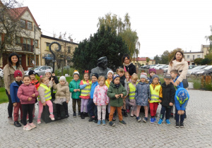 Dzieci z grupy Biedronek wraz z panią Anetką, panią Renatką i panią Kamilką stoją pod pomnikiem Jana Łaskiego.