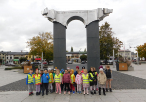 Dzieci z grupy Biedronek stoją pod pomnikiem "Walczącym o niepodległość Ojczyzny".
