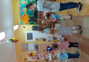 Dzieci uczą gościa zabawy „Siedzi zajączek” (jest nim Nikoś).