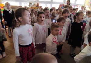 Przedszkolaki śpiewają hymn narodowy pamiętając o zachowaniu należytej postawy.