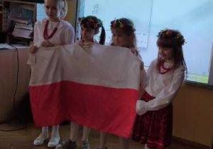 Dziewczynki z dumą prezentują Polską flagę.