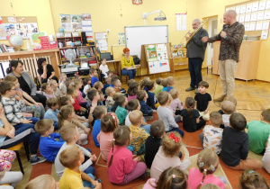 Pan Feliks pokazuje przedszkolakom część puzonu zwaną suwakiem.