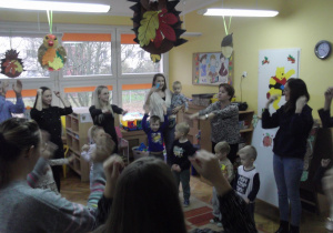 Rodzice wspólnie z dziećmi ćwiczą przy piosence „ Głowa, ramiona”.