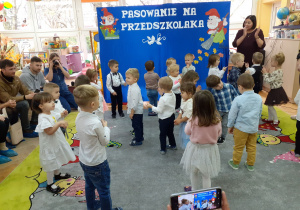 Pani Halinka pomaga śpiewać dzieciom, tańczącym w parach.