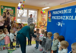 Pani dyrektor gratuluje Zuzi przyjęcia do grona przedszkolaków.
