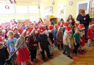 Krasnoludki z tanecznym krokiem śpiewają piosenkę „ Taniec dla Mikołaja”.