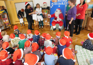 Pani Dyrektor pomaga Mikołajowi rozdawać prezenty.