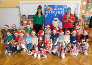 Grupa "Krasnoludków" na pamiątkowym zdjęciu z Mikołajem i elfami.