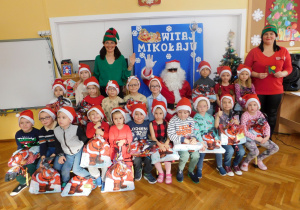 Grupa Słoneczek pozuje do zdjęcia z Mikołajem i elfami.