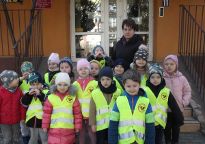 Przedszkolaki wraz z panią Renią przed budynkiem przedszkola.