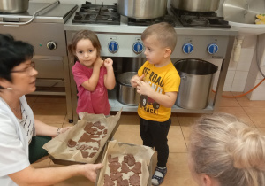 Iga i Nikodem zanieśli zrobione pierniczki do przedszkolnej kuchni, aby je upiec.