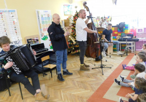 Pan Feliks z muzykami grają na instrumentach.