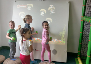 Dzieci bawią się przy tablicy interaktywnej.