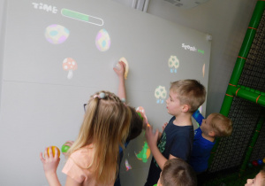 Dzieci z grupy "Żabek" grają na tablicy interaktywnej.