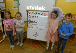 Basia, Laura, Zuzia i Filipek stoją przy tablicy na której ułożyli puzzle.