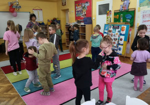 Dzieci w parach wskazują części ciała podczas zabawy ruchowej.