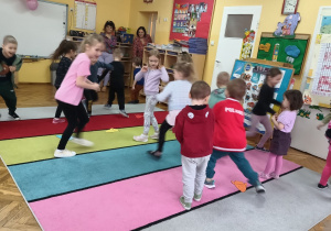 Dzieci uczestniczą na dywanie w zabawie ruchowej "Kolorowe rakiety".