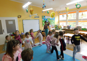 Dzieci tańczą w rytm muzyki podczas zabawy ruchowej z kostką .
