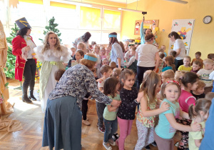 Pracownicy przedszkola zapraszają dzieci do wesołego korowodu przy dźwiękach piosenki "Wiosna".