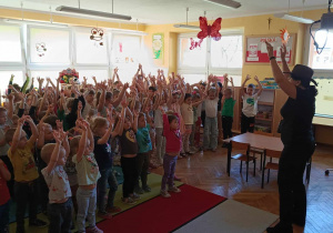 Przedszkolaki recytują wierszyk „W górze słonko świeci” z pokazywaniem.