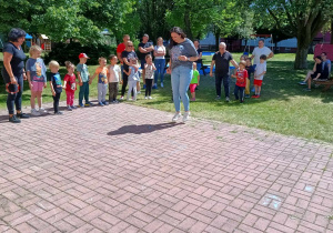 Mama Karinki skacze do w grze „Klasy”, a pozostali kibicują.