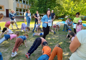 Dzieci i rodzice naśladują kotka, który wygina swój grzbiet.