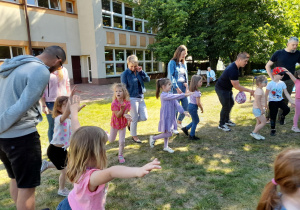 Dzieci i rodzice naśladują bociana w zabawie.